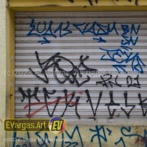 yellowish street wall with graffiti on it, and a large metal curtain window