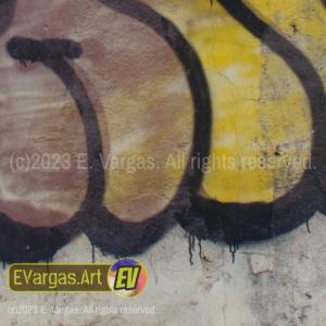 closeup of a yellowish street wall with graffiti on it